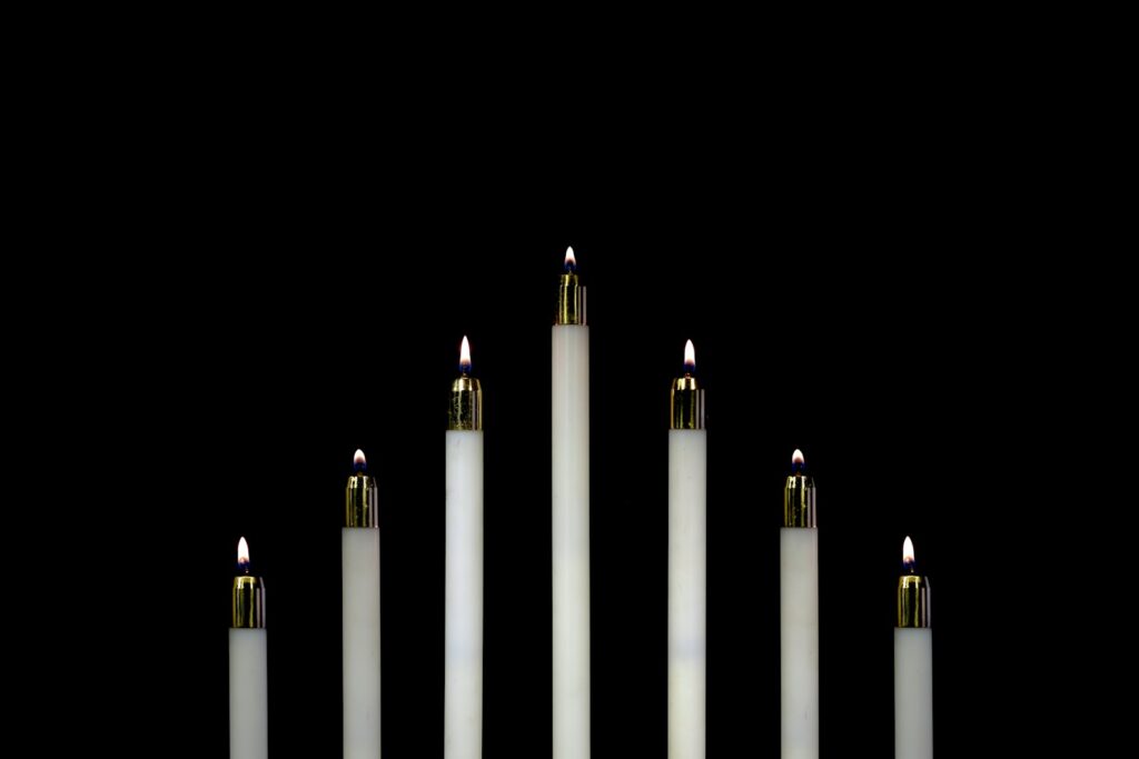 seven white candles closeup photography