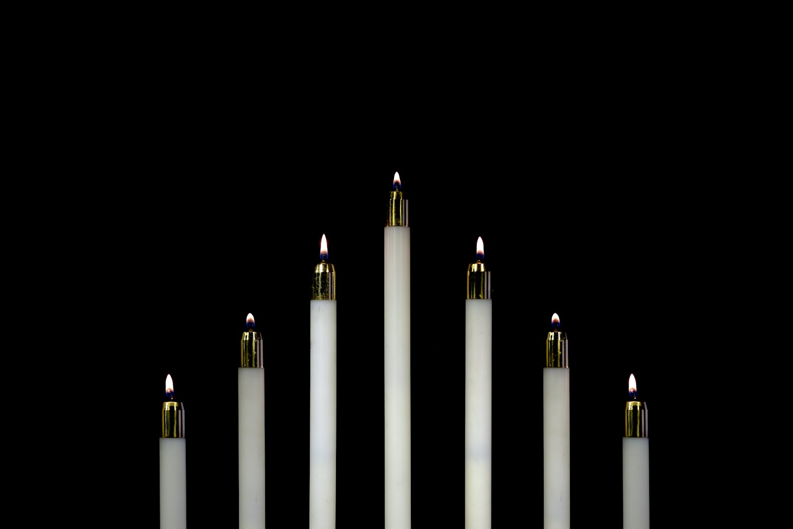 seven white candles closeup photography