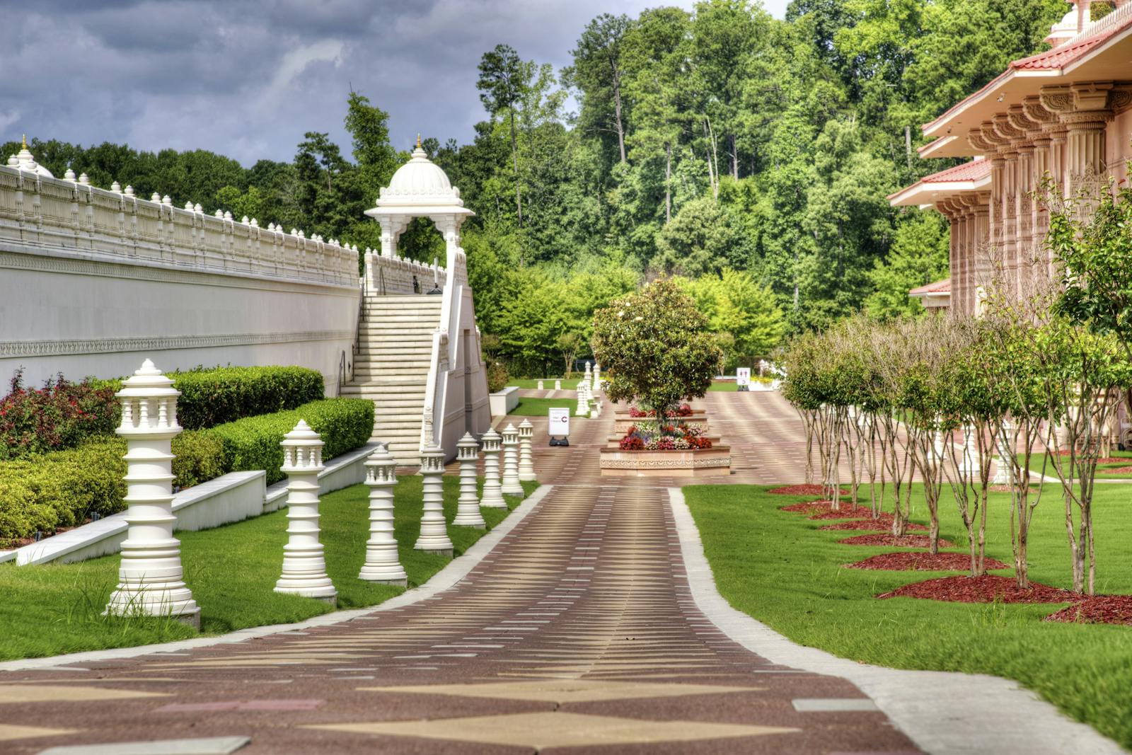 Peaceful garden view showcasing ornate architecture and lush greenery on a sunny day.